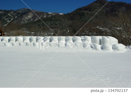 冬の長野県木曽町開田高原は雪の積もった牧場があり、その先には冠雪した御岳山が見えます。 134702137
