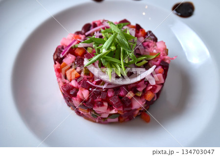 A beautiful white plate with a vibrant salad of beets, carrots, and onions A beautiful white plate with a vibrant salad of beets, carrots, and onions 134703047