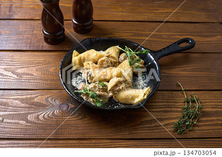 Enjoy savory crepes topped with creamy mushroom sauce 134703054