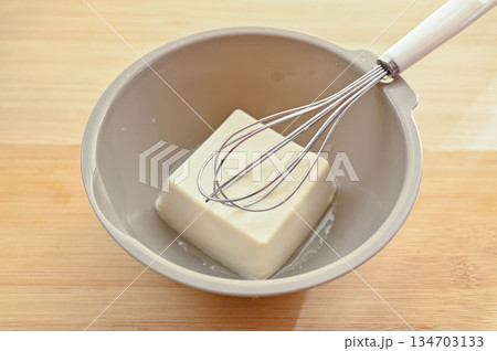 ボウルに入れた絹ごし充填豆腐と泡だて器 ボウルに入れた絹ごし充填豆腐と泡だて器 134703133