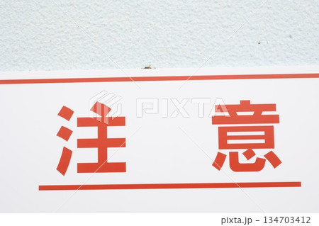 赤文字の注意看板クローズアップ。シンプルな注意喚起概念。 赤文字の注意看板クローズアップ。シンプルな注意喚起概念。 134703412