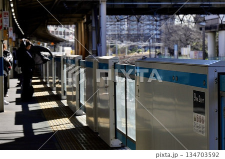 朝の駅のホームと上着を羽織るサラリーマン 134703592
