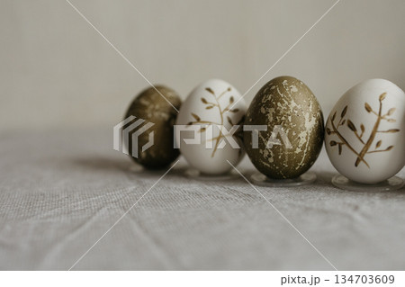 Easter holiday. Painted olive-colored eggs on a linen tablecloth. Easter decoration. 134703609