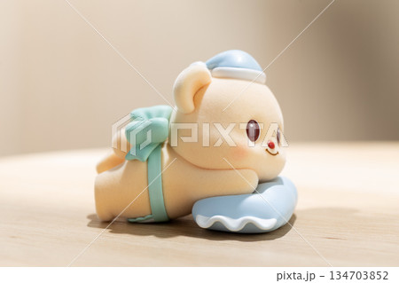 ButterBear Art Toy Rests on Blue Pillow in Playful Display ButterBear Art Toy Rests on Blue Pillow in Playful Display 134703852