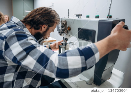 People are working by the sewing machines indoors People are working by the sewing machines indoors 134703904