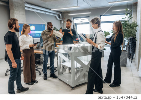 People are in the office by the 3d printer People are in the office by the 3d printer 134704412