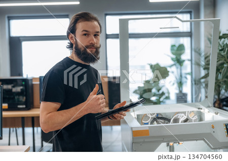 Standing, working. Man is in the office with 3d printer 134704560