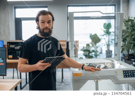 Standing, working. Man is in the office with 3d printer 134704561