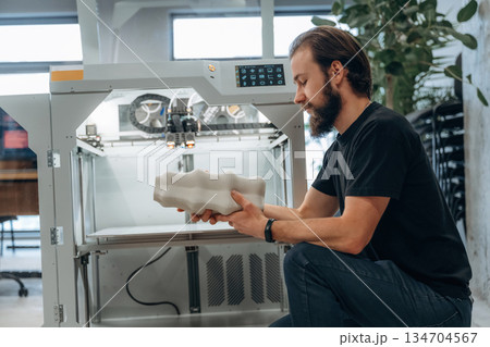 Product is ready. Man is in the office with 3d printer Product is ready. Man is in the office with 3d printer 134704567