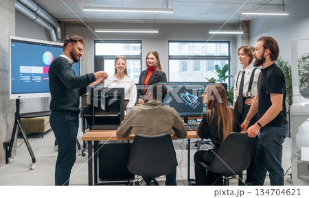 3d printer is on the table. Designer team are together in the office 3d printer is on the table. Designer team are together in the office 134704621