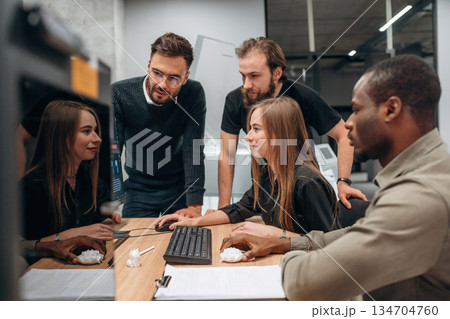 By computer. Designer team are together in the office By computer. Designer team are together in the office 134704760