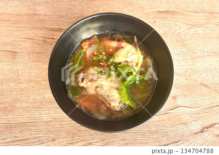 spicy chicken meat with onion and tomato in tom yum soup on bowl 134704788