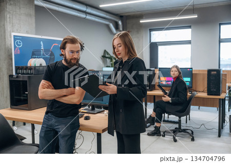 Display with 3d printing software. Designer team are together in the office Display with 3d printing software. Designer team are together in the office 134704796