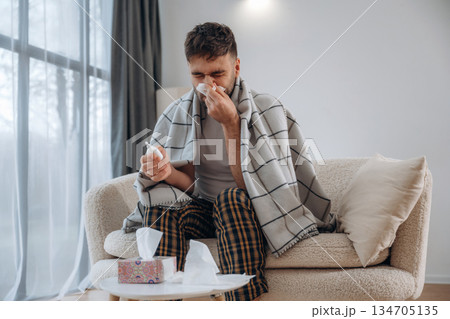 Nasal spray for nose. Sick man is feeling bad at home Nasal spray for nose. Sick man is feeling bad at home 134705135
