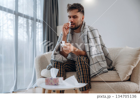 Nasal spray for nose. Sick man is feeling bad at home 134705136