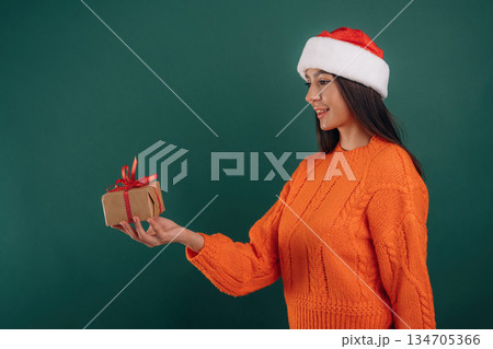 New year gift box in hands. Young beautiful woman is against background 134705366