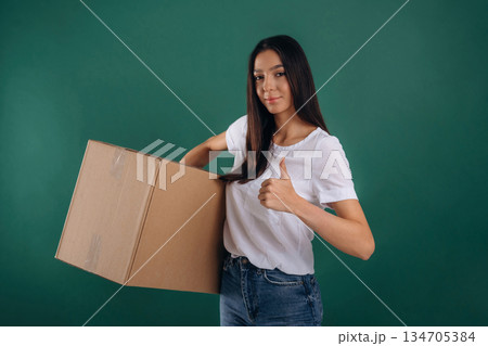 Delivery service, holding box. Young beautiful woman is against background 134705384