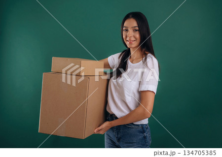 Delivery service, holding box. Young beautiful woman is against background 134705385