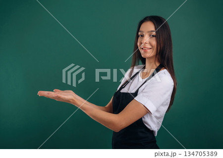 Copy space, showing invisible object. Young beautiful barista is against background 134705389
