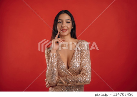 Looking forward, standing. Young elegant woman is against background 134705456