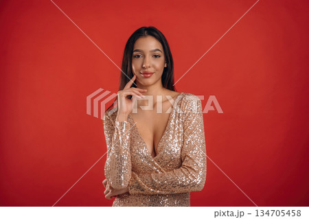 Looking forward, standing. Young elegant woman is against background 134705458