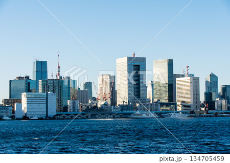 真っ青な青空の下のお台場近くの広々とした東京湾の海面と遠くに見える東京の高層ビル群 134705459