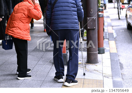 日本の東京都市景観年の瀬。高齢化社会。タクシーが拾えず携帯電話で呼ぶ高齢女性。杖の男性は歩くのが… 134705649