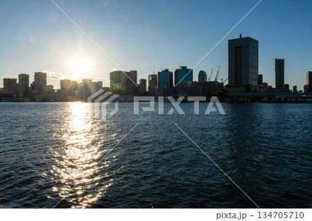 真っ青な青空と眩しい太陽の下のお台場近くの広々とした東京湾の海面と遠くに見える東京の高層ビル群 134705710