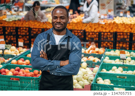 Grocery store worker in apron is near products Grocery store worker in apron is near products 134705755