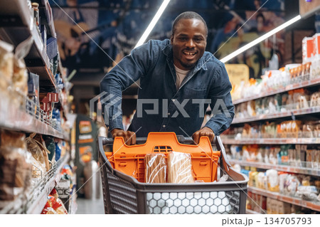 Smiling, positive facial expression. Man customer is in the supermarket Smiling, positive facial expression. Man customer is in the supermarket 134705793