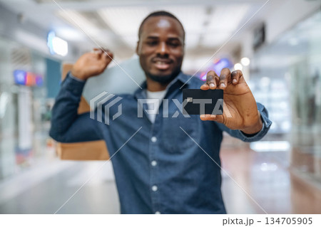 Credit card for shopping. Black man is in the hall of the supermarket 134705905