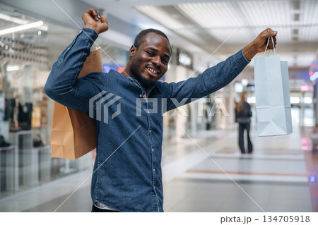 Hands up, happy customer. Black man is in the hall of the supermarket 134705918