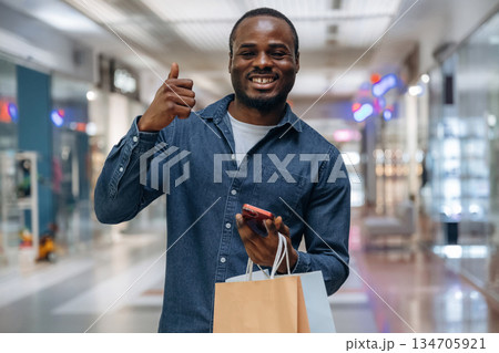 Black man is in the hall of the supermarket Black man is in the hall of the supermarket 134705921