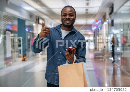 Black man is in the hall of the supermarket Black man is in the hall of the supermarket 134705922