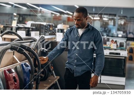 Vacuum cleaners. Man in a home appliance store 134705930