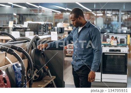 Vacuum cleaners. Man in a home appliance store 134705931