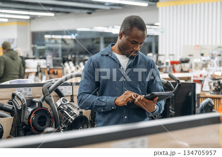 Worker is in the home appliance store Worker is in the home appliance store 134705957