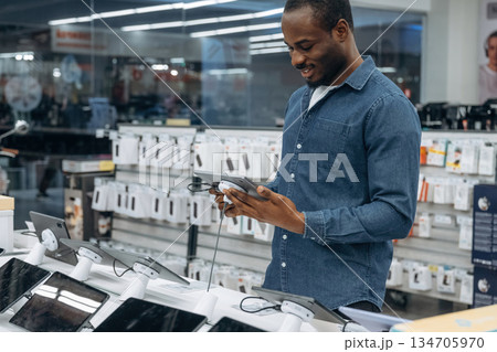 Digital tablet in hands. Man in a home appliance store Digital tablet in hands. Man in a home appliance store 134705970