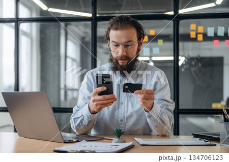 Transaction, using credit card and phone. Businessman is working in the office 134706123