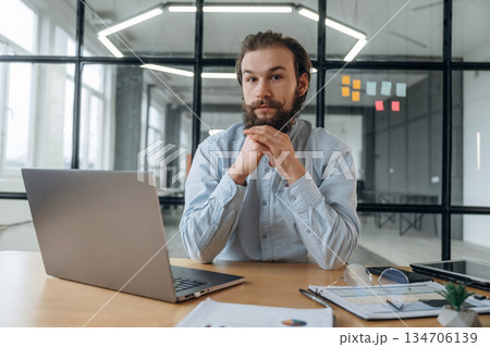 Front view, by laptop. Businessman is working in the office Front view, by laptop. Businessman is working in the office 134706139
