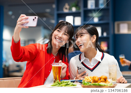 飲み会で写真を撮る若い女性 134706186