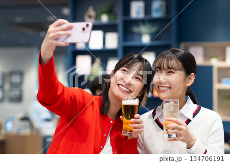 飲み会で写真を撮る若い女性 134706191
