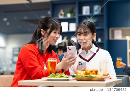 女子会でスマホを見る若い女性 女子会でスマホを見る若い女性 134706483