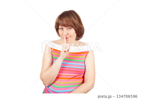 Smiling Woman Making Silence Gesture Looking at Camera Smiling Woman Making Silence Gesture Looking at Camera 134706596