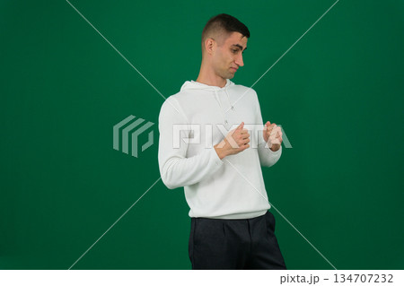 a man holding his hands in fists in front of him young well-groomed european brunette guy with a beard and mustache holds his fists in front of him 134707232