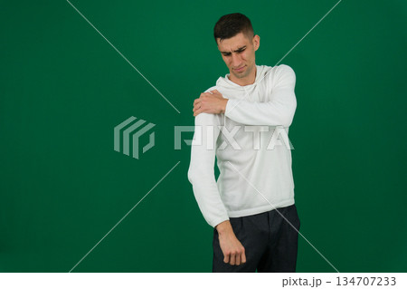 Close-up side view of a young businessman suffering from shoulder pain against white background 134707233