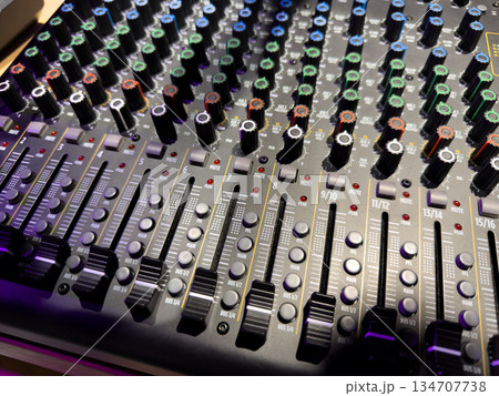 Adjusting sound with music panel. Connecting music devices to sound, bass and volume controller. Intricate sound and music controls. Learning music controls and DJing 134707738