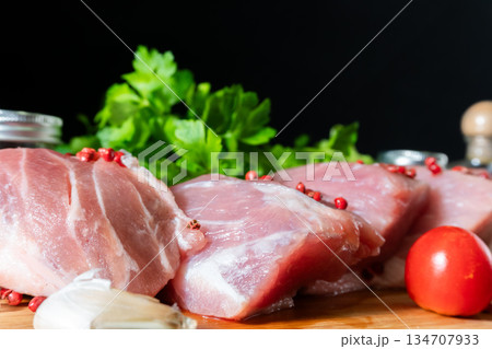 Raw Meat with Tomatoes Garlic and Parsley on Cutting Board 134707933