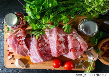 Raw Meat with Tomatoes and Parsley on Cutting Board Raw Meat with Tomatoes and Parsley on Cutting Board 134707934