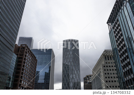 Low Angle View of Modern Skyscrapers in Cloudy City Low Angle View of Modern Skyscrapers in Cloudy City 134708332